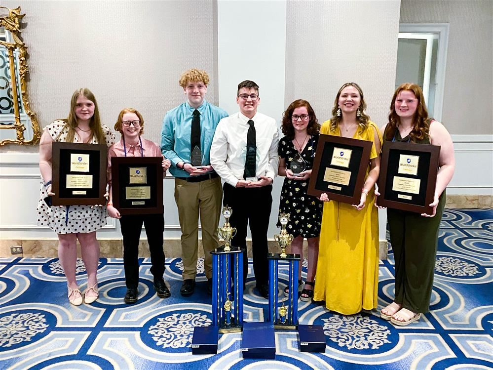 seven students stand among choral awards