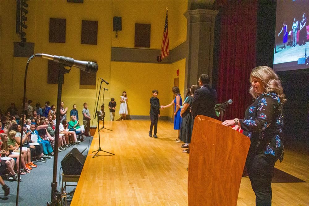 image of students crossing stage at Grade 6 moving up ceremony.