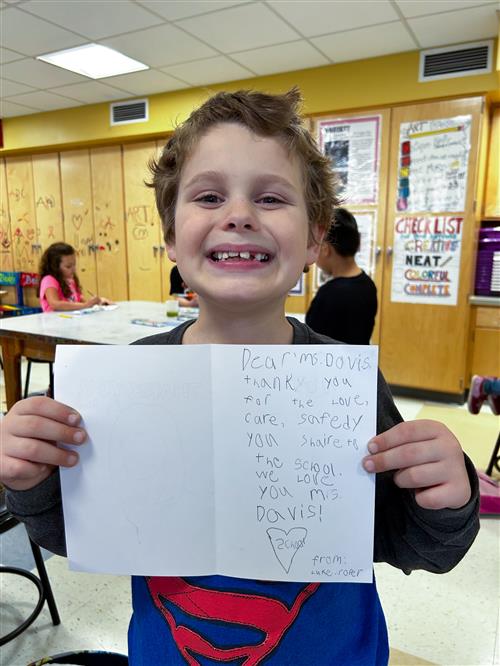 Student holding thank you card to BOE member