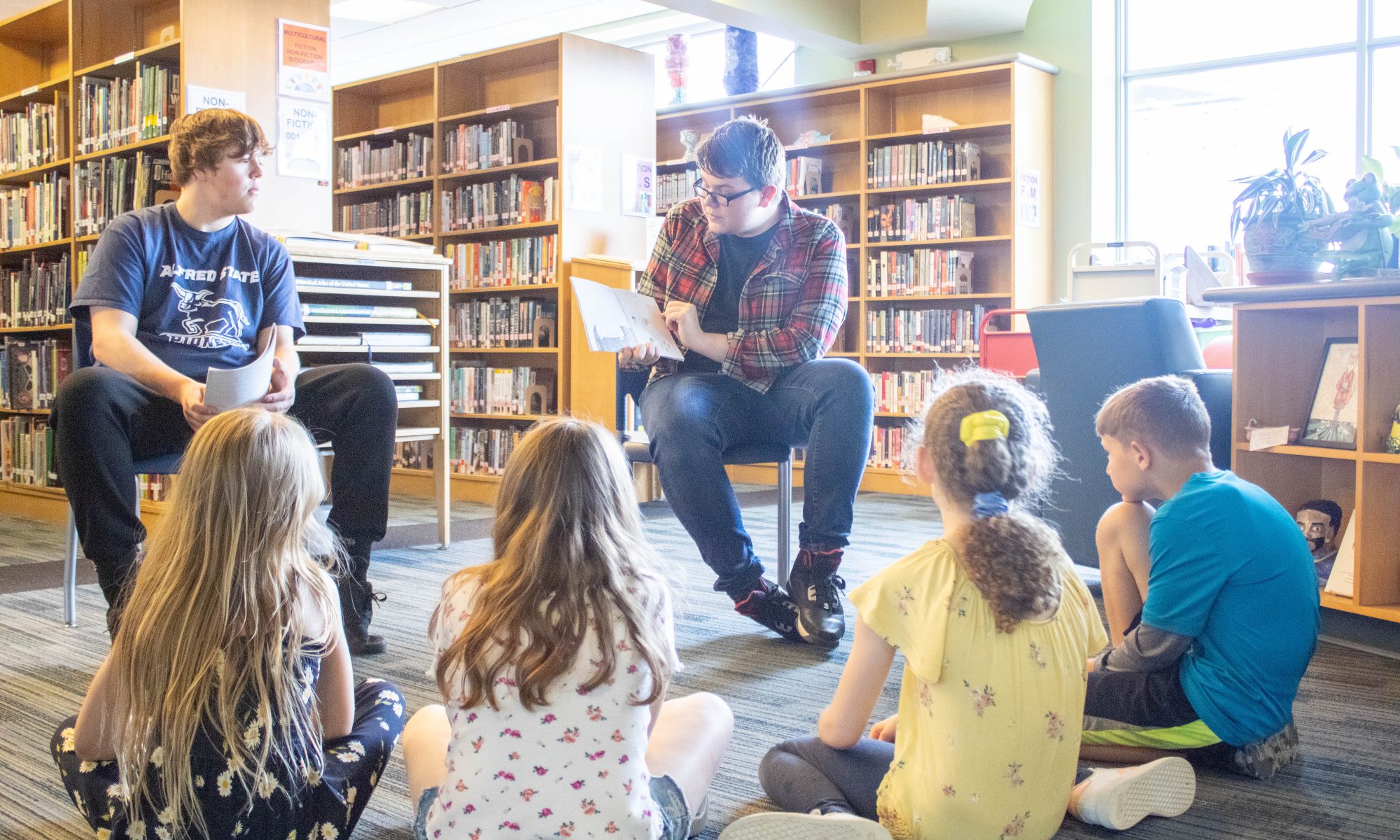 seniors read their books to fourth graders in the library