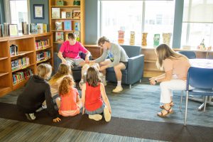 seniors read their books to fourth graders in the library